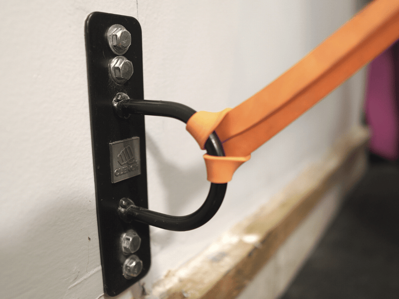 Close-up image of resistance band attached to wall anchor, demonstrating proper set-up for exercises